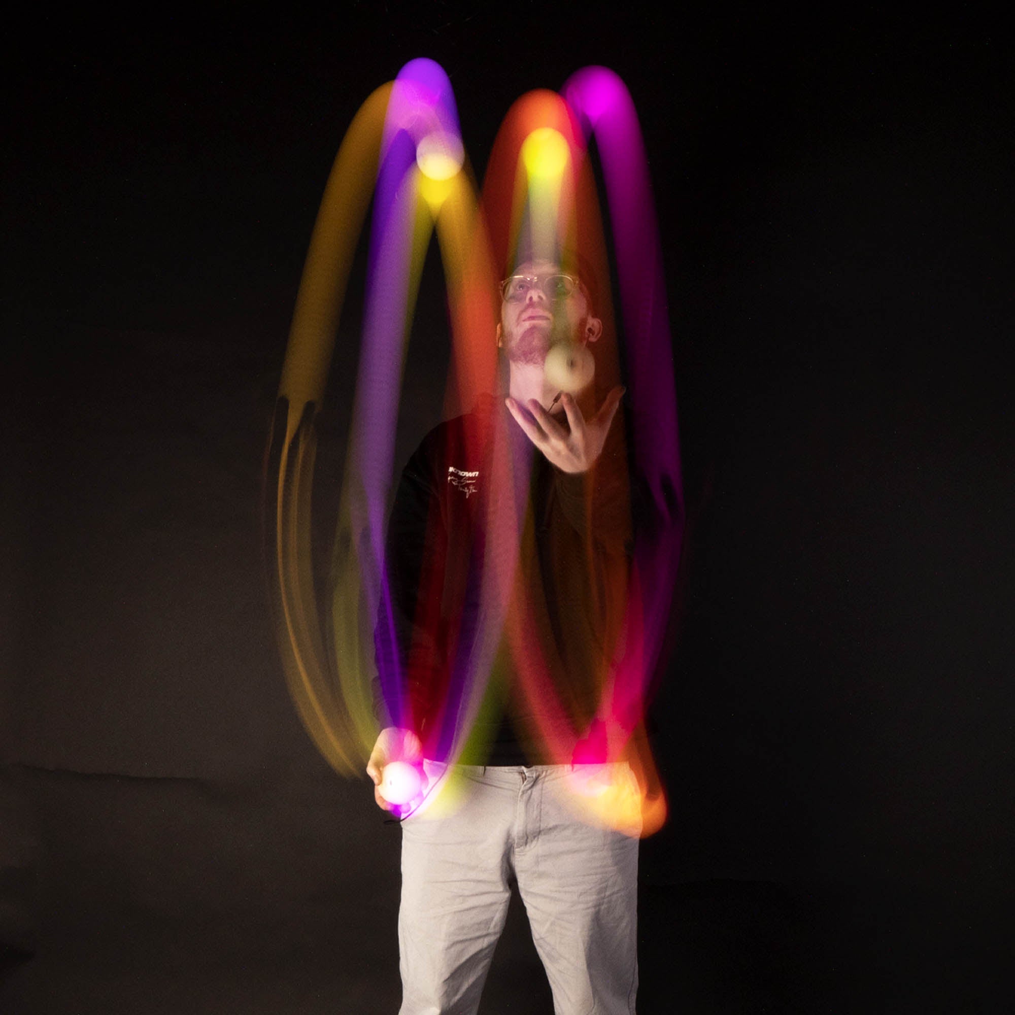 balls being juggled with light trails