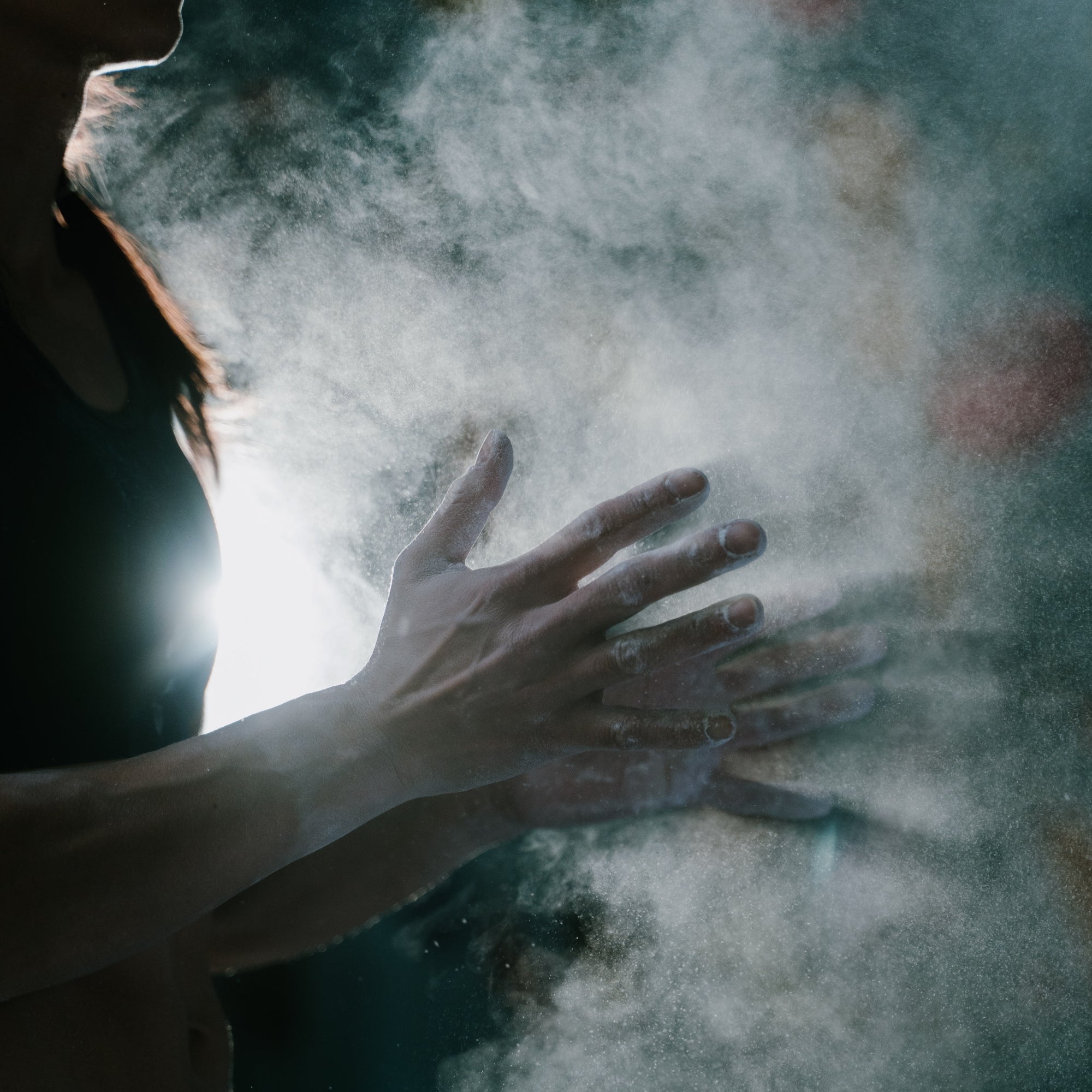 person with chalky hands and chalk dust