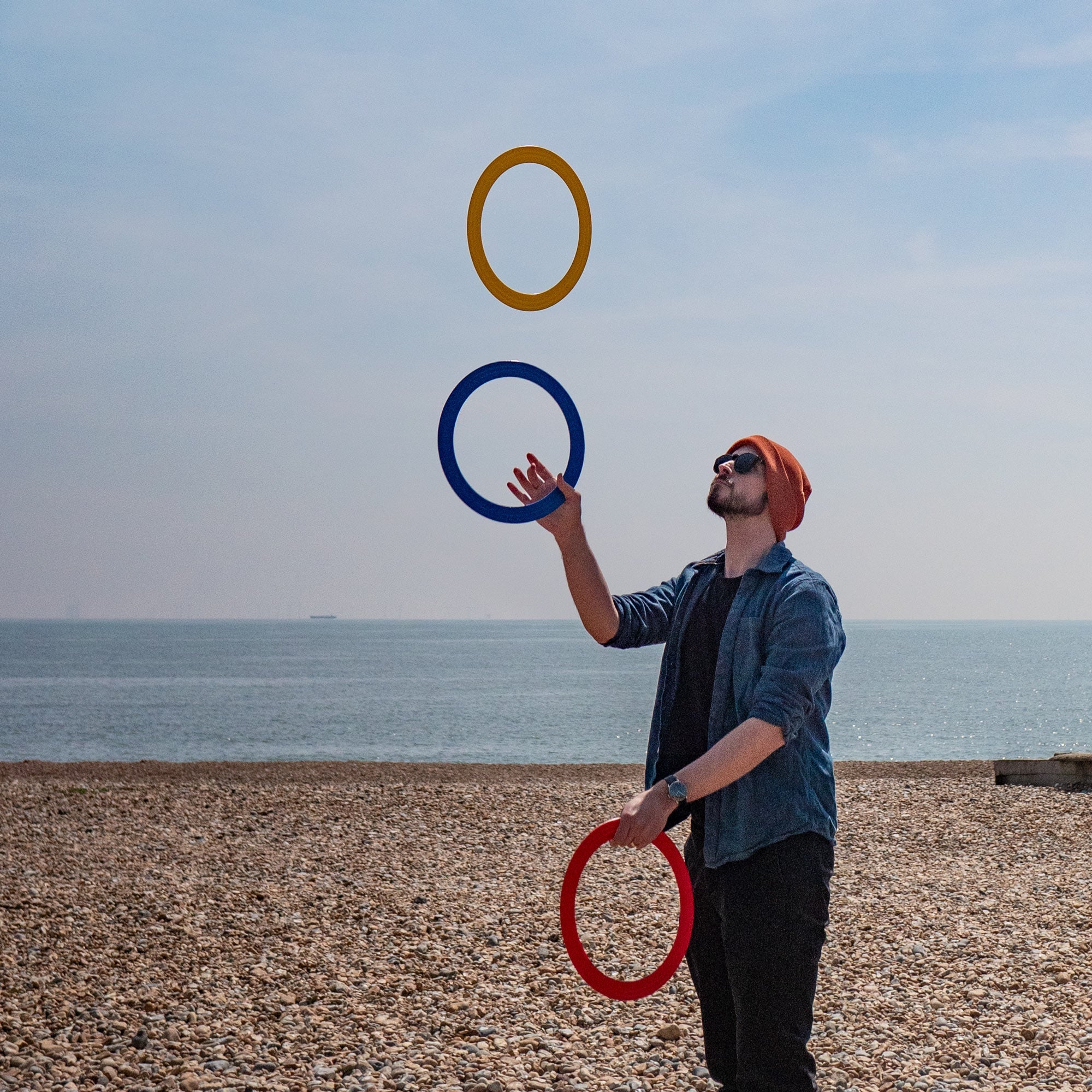 performer with 3 rings on a beach